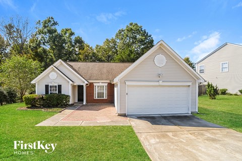 a white house with a white garage door and a lawn