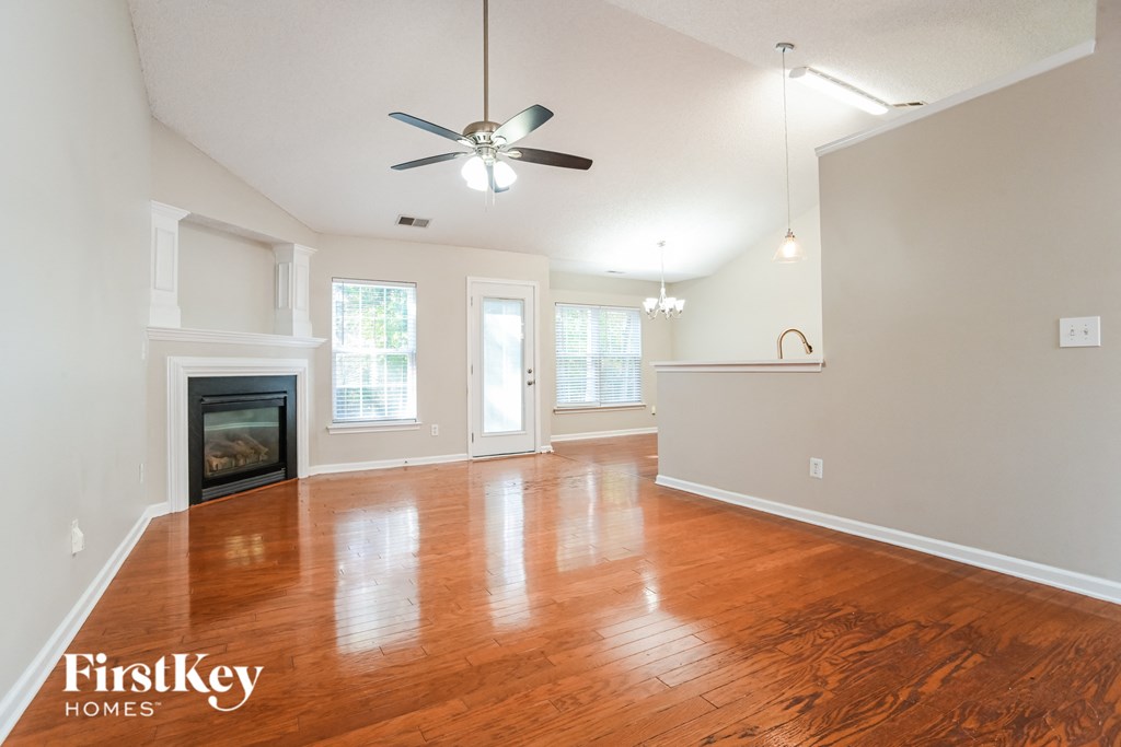 an empty living room with wood floors and a fireplace