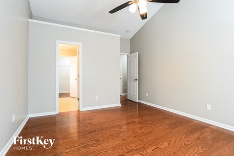 a living room with wood floors and a ceiling fan