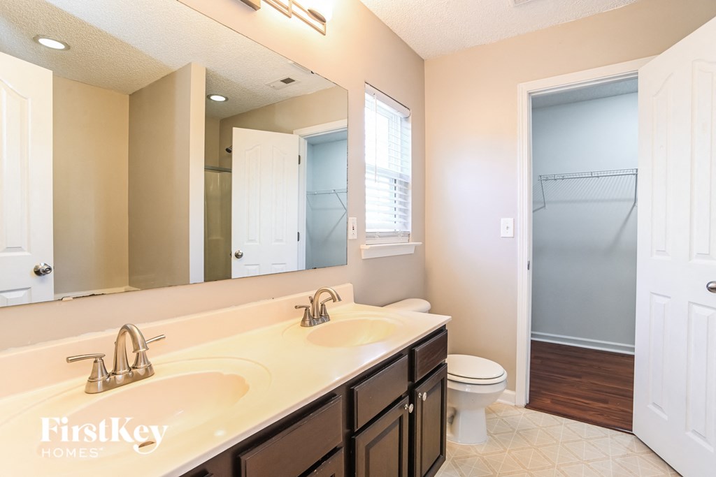 a bathroom with a large mirror and a toilet and a sink