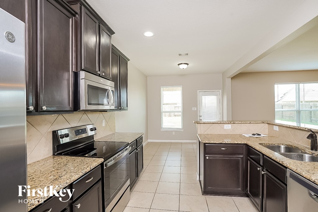 A kitchen with dark brown cabinets and stainless steel appliances.