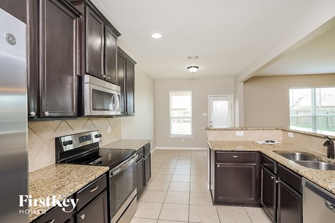 A kitchen with dark brown cabinets and stainless steel appliances.