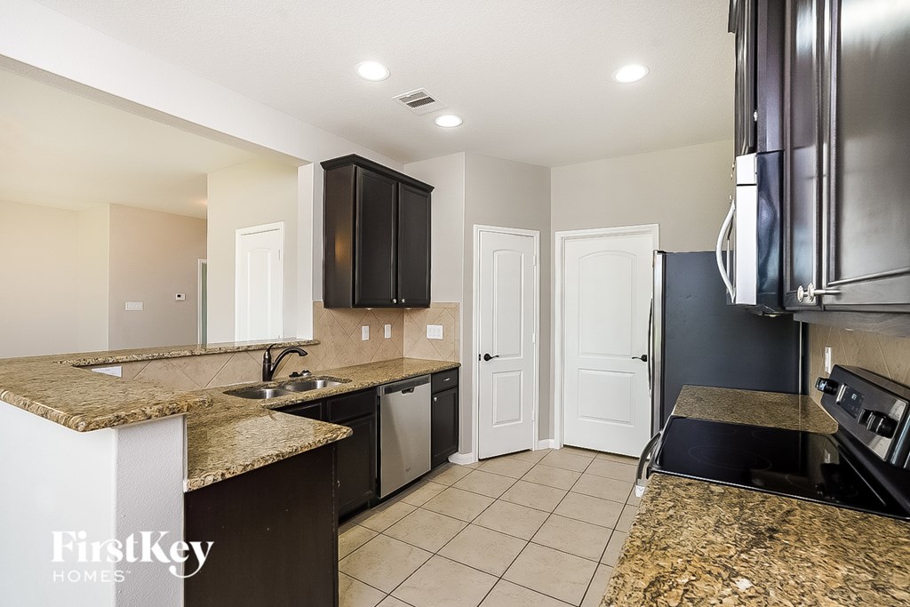 A kitchen with granite countertops and stainless steel appliances.