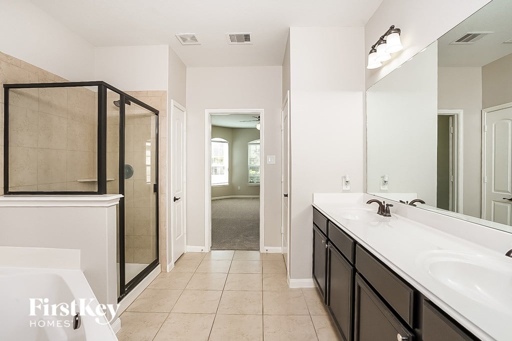 A bathroom with a white sink and black cabinets.