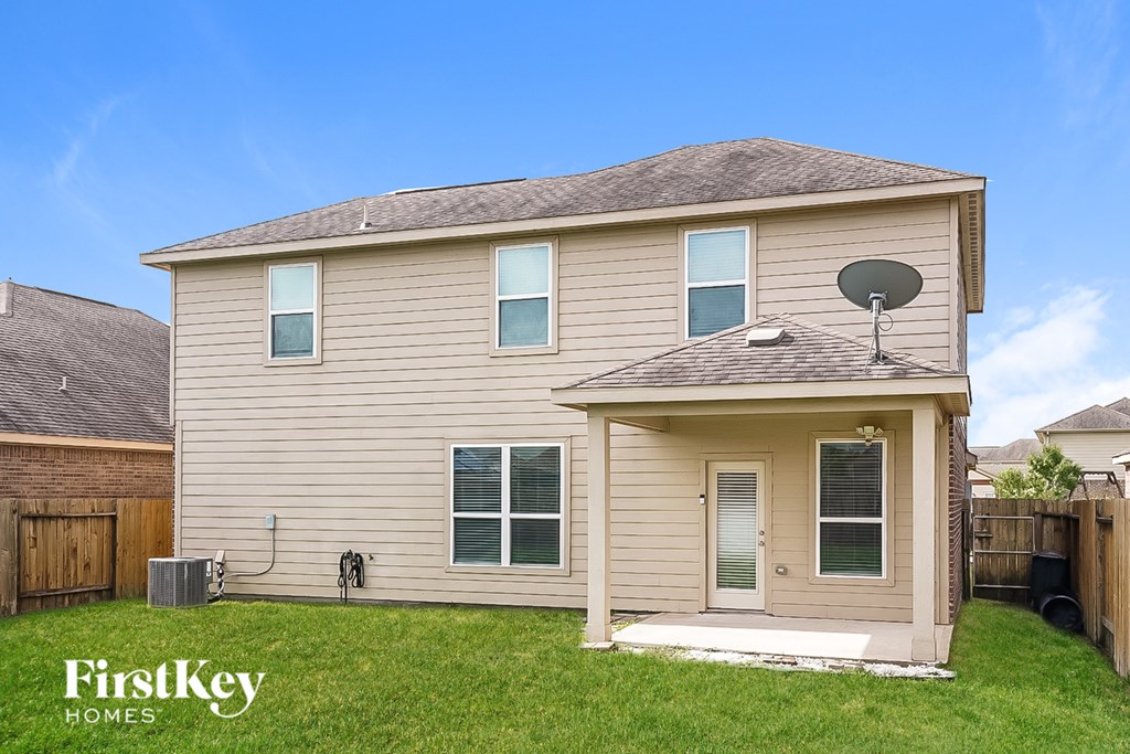 A beige house with a satellite dish on the roof.