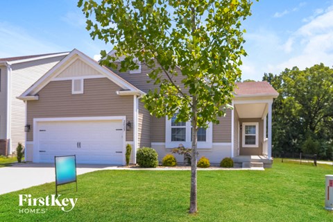 a house with a lawn and a tree in front of it