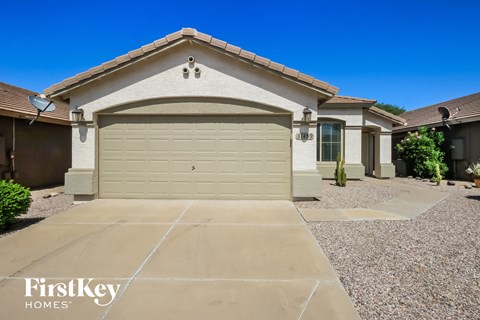 A house with a garage door and a driveway in front of it.
