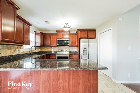 A kitchen with brown cabinets and a FirstKey Homes sign.