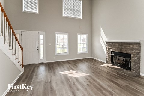 an empty living room with a fireplace and a staircase