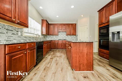 A kitchen with wooden cabinets and a stone countertop.