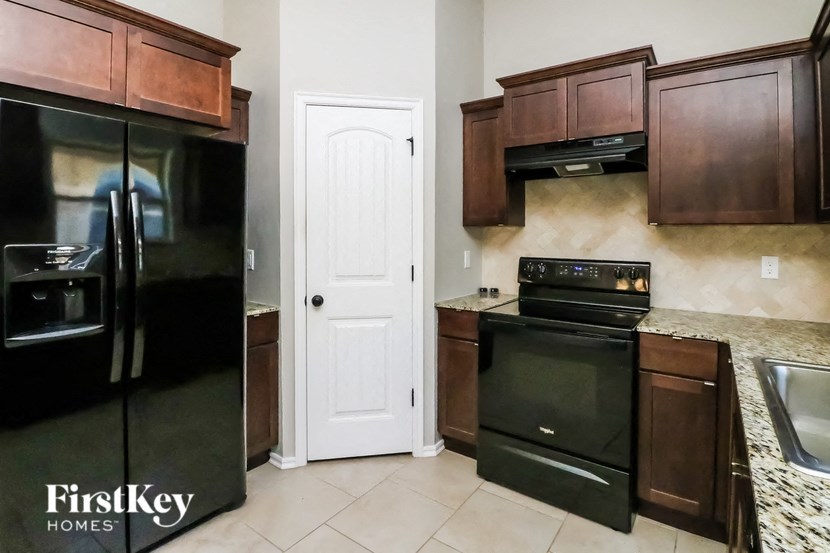 a kitchen with black appliances and brown cabinets