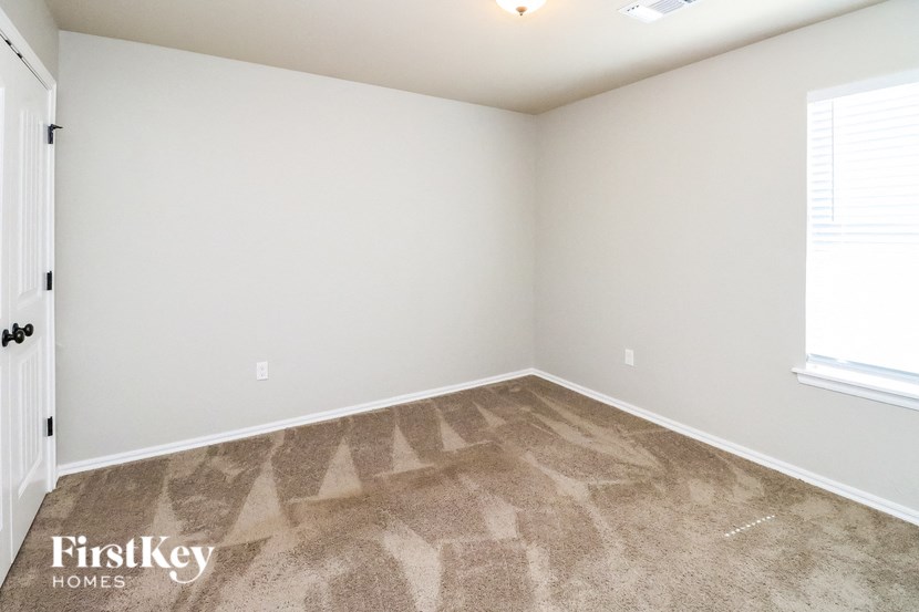 a bedroom with a carpeted floor and a window