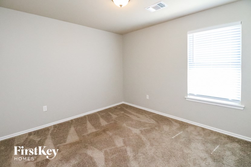 the upstairs bedroom with carpeted flooring and a window
