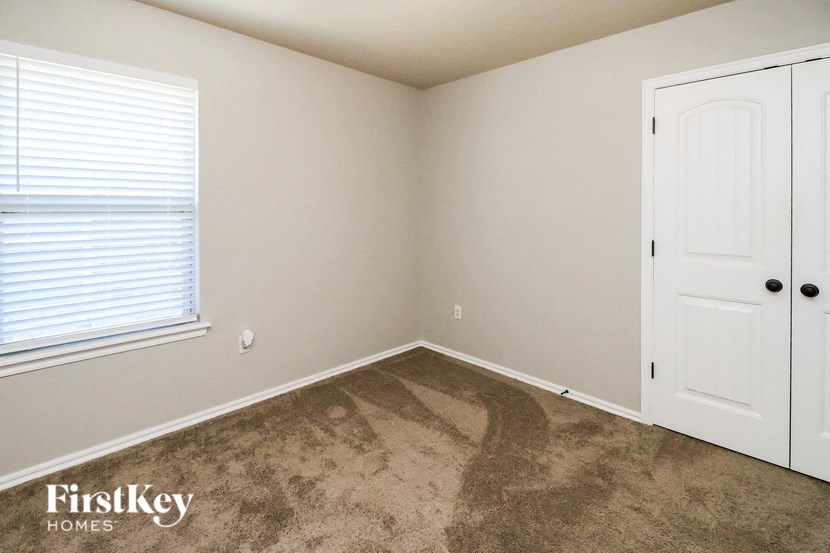 the bedroom of a home with a carpeted floor and a white door
