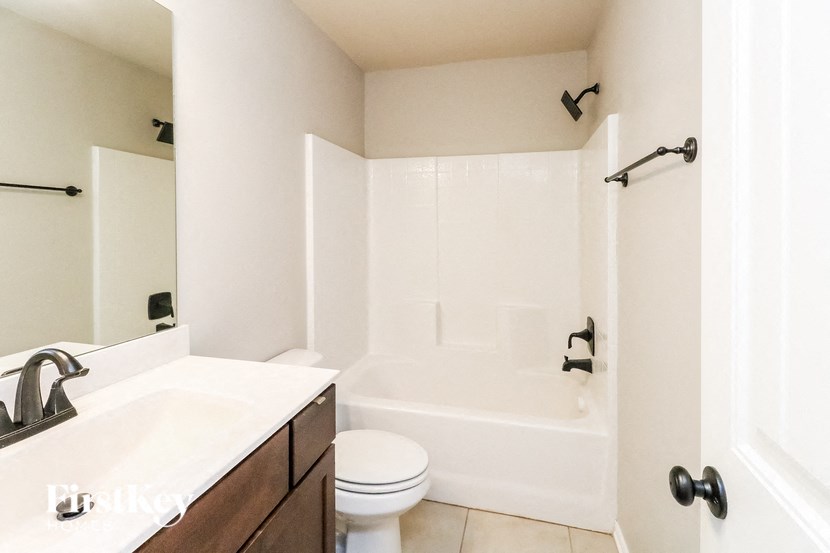 a bathroom with a toilet and a tub and a sink