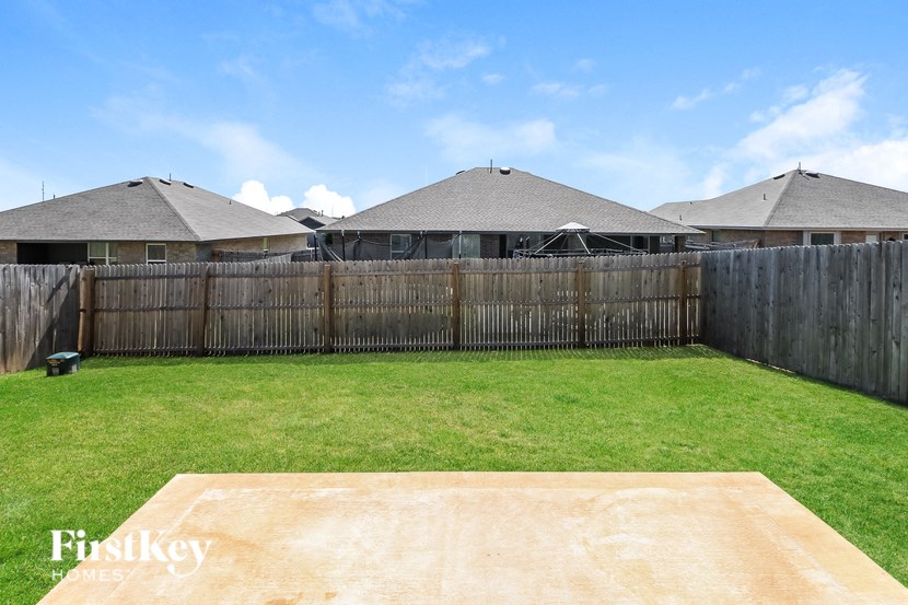 a backyard with a wooden fence and grass