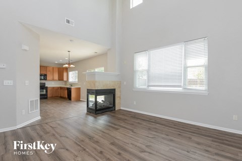 the living room and kitchen of an open floor plan with a fireplace
