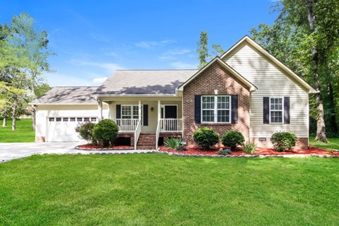 a house with a lawn and a white garage door