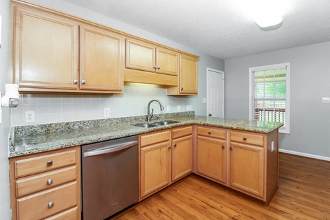 a kitchen with wooden cabinets and granite counter tops