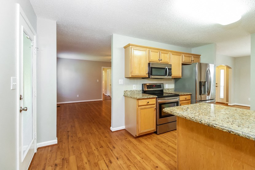 an empty kitchen with wood flooring and