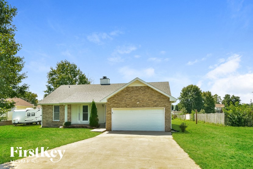 a small brick house with a white garage door