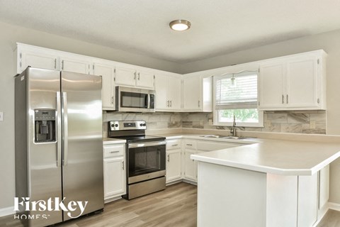 a kitchen with white cabinets and stainless steel appliances