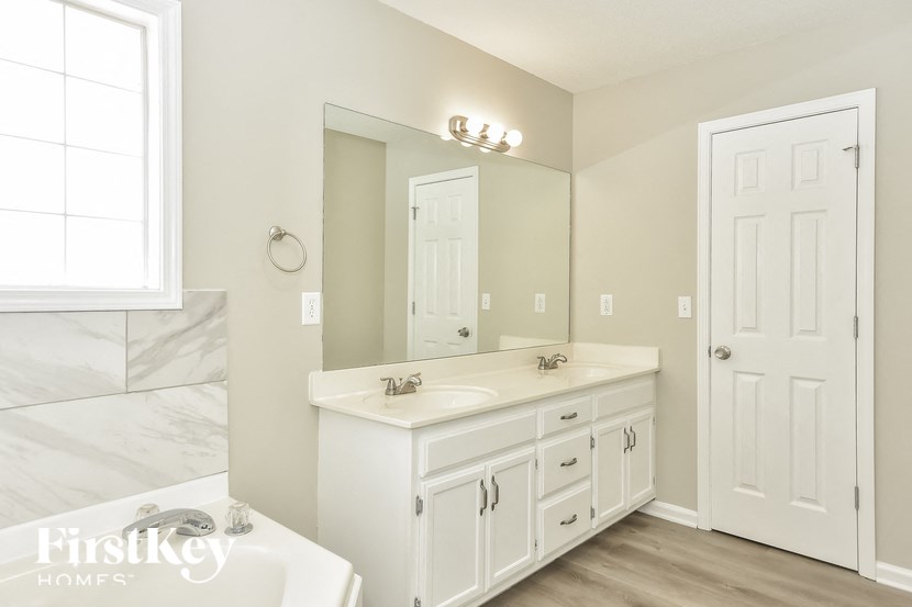 a white bathroom with a sink and a mirror