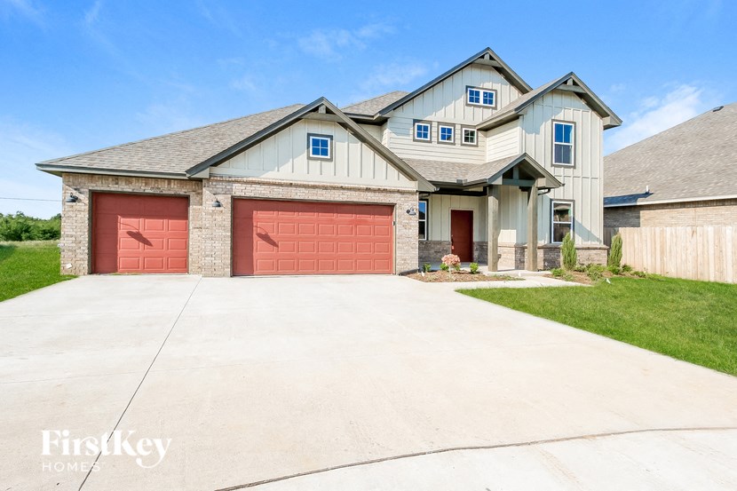 a white house with two red garage doors
