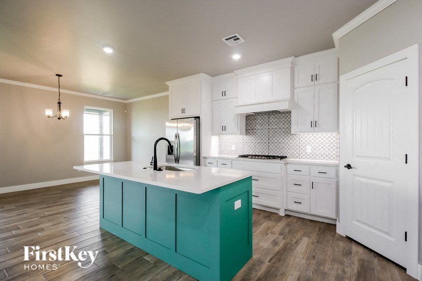 a turquoise island in a white kitchen with white cabinets