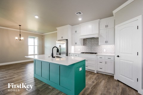 a turquoise island in a white kitchen with white cabinets