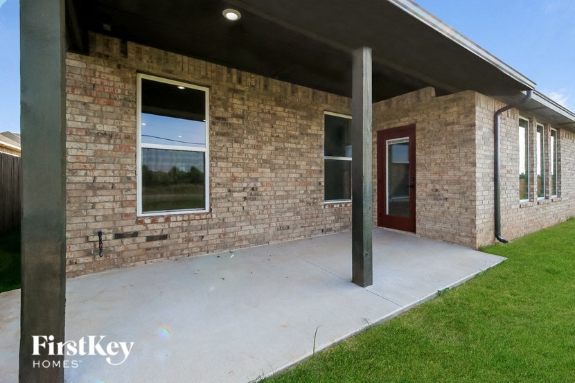 the front of a brick building with a porch and a red door