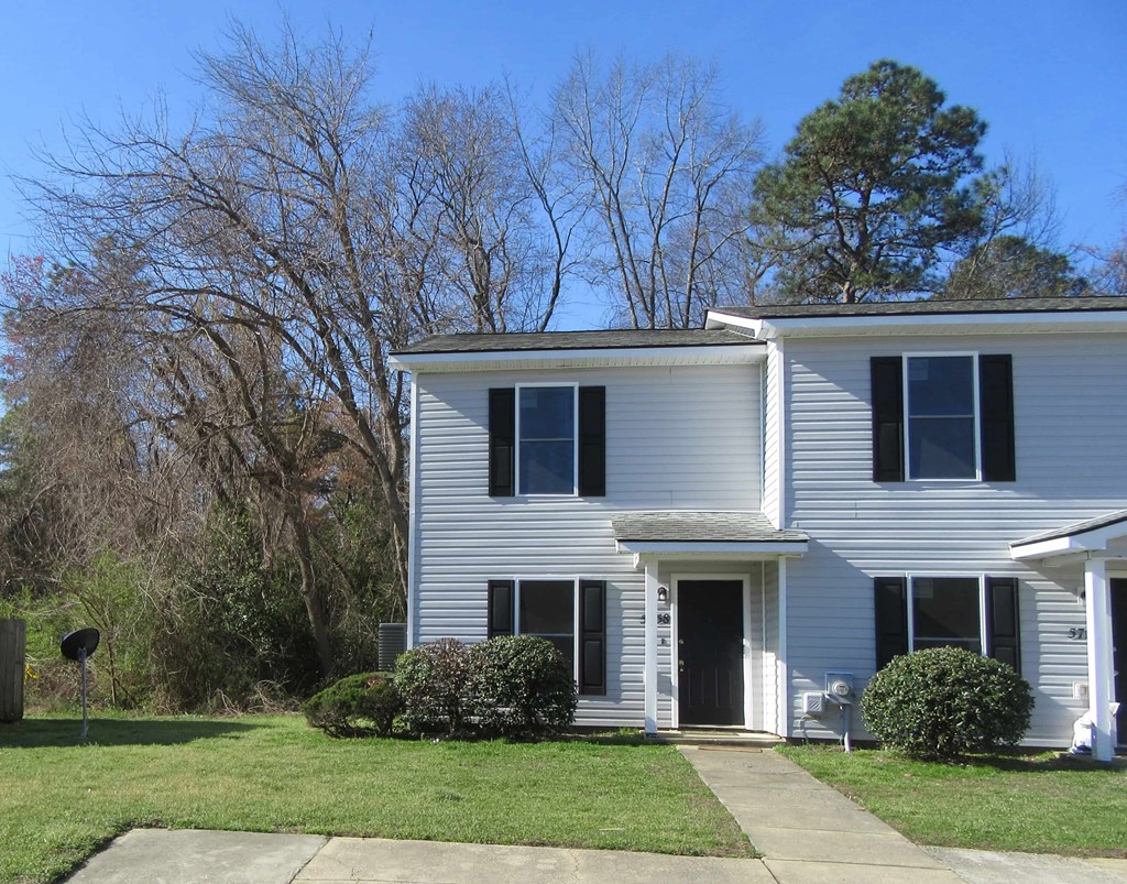 a white house with a lawn in front of it