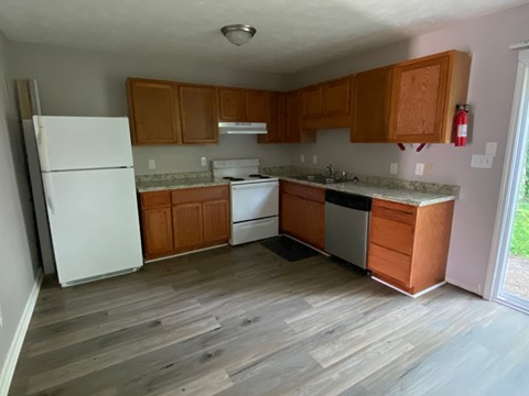 a kitchen with white appliances and wooden cabinets