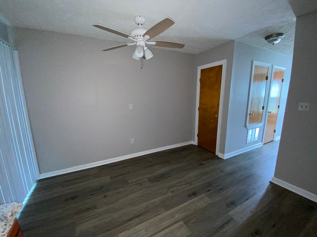 a living room with wood floors and a ceiling fan