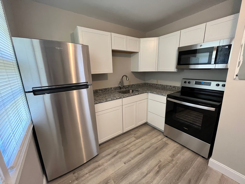 a kitchen with stainless steel appliances and white cabinets