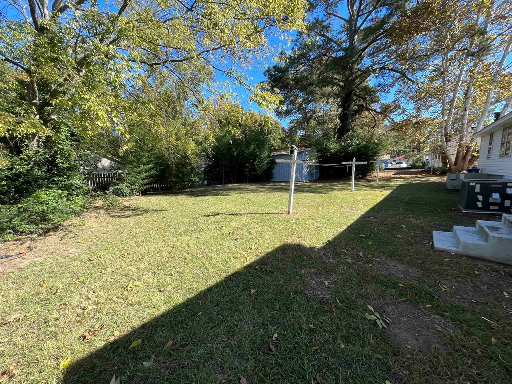 a backyard with a house and a yard with grass and trees