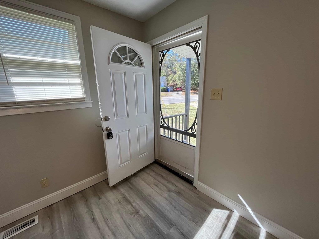 a door opens into a living room with a balcony