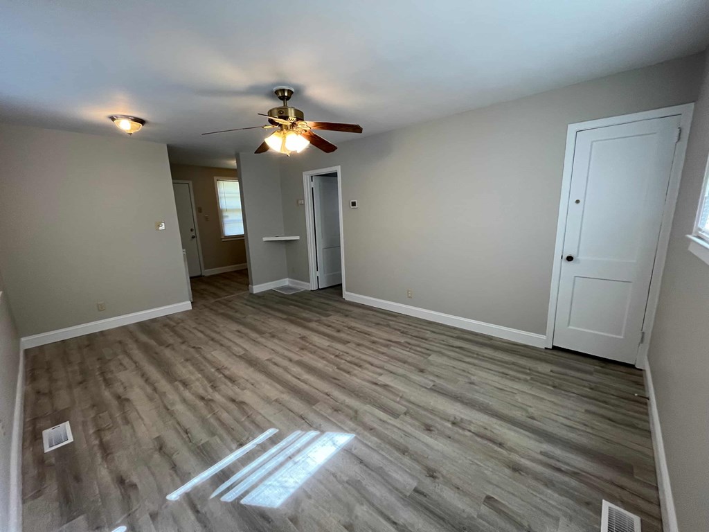 a living room with wood floors and a ceiling fan
