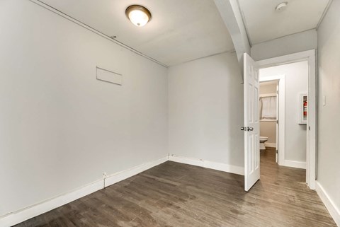 a living room with white walls and a wood floor