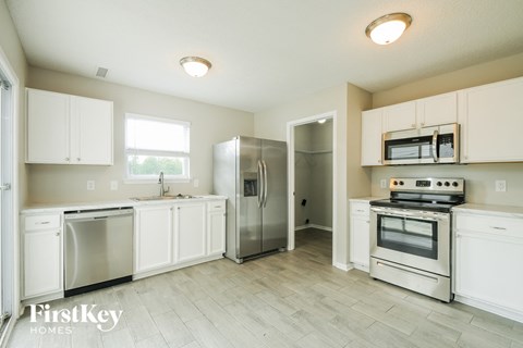 a kitchen with white cabinets and stainless steel appliances
