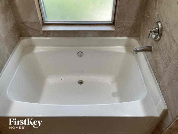 a white bath tub in a bathroom next to a window