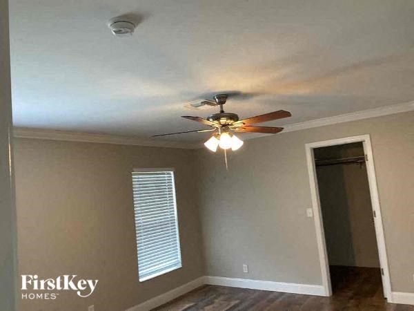 a living room with a ceiling fan and a closet