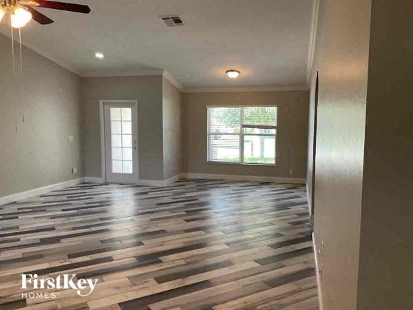 a empty living room with wood floors and a window