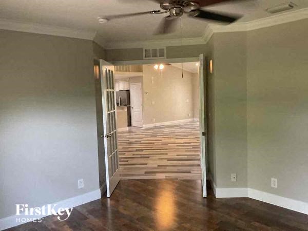 a living room with wood floors and a ceiling fan