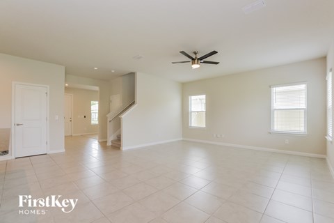 A spacious room with a ceiling fan and tiled flooring.