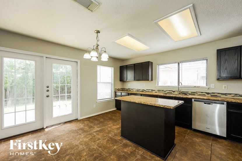 a kitchen with an island and a door to a patio