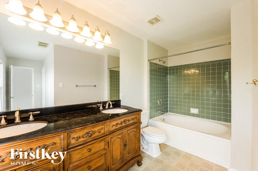 a bathroom with two sinks and a tub and a toilet