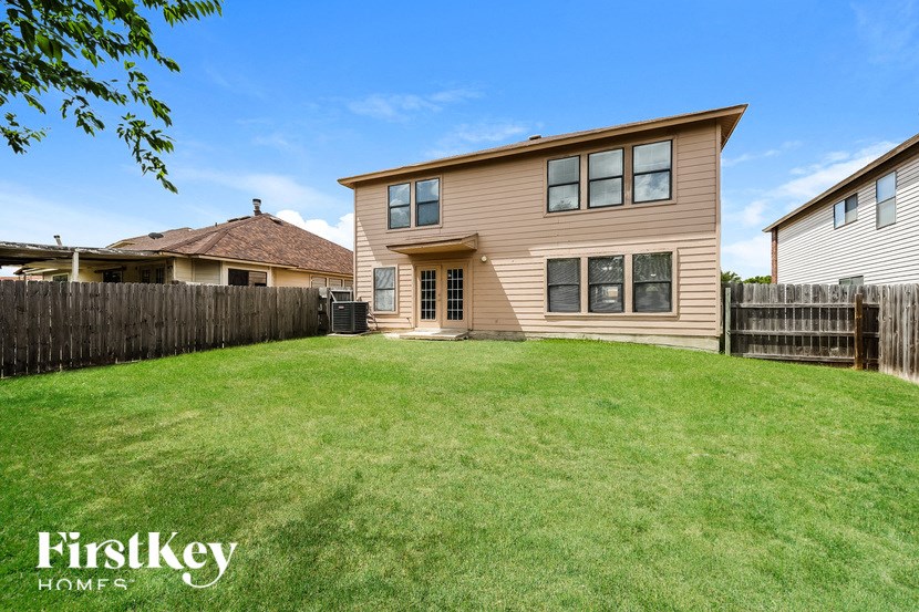 a backyard with a house and a yard with a fence