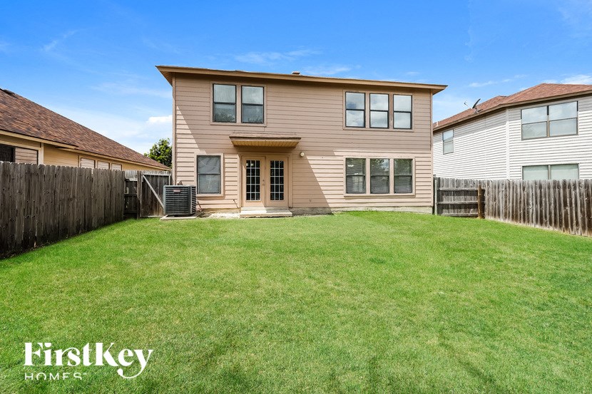 a backyard with a house and a grass lawn