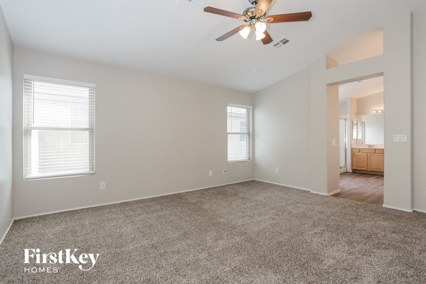 an empty living room with a ceiling fan